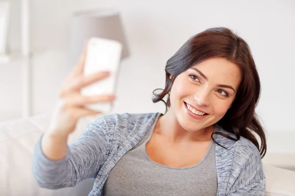 Mulher feliz tomando selfie com smartphone em casa — Fotografia de Stock