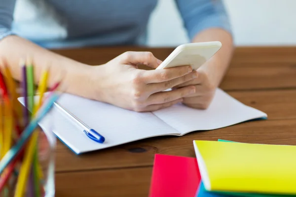 Close up of student with smartphone and notebook — Stock Photo, Image