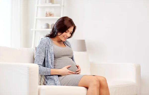 Gelukkig zwangere vrouw zittend op de Bank thuis — Stockfoto