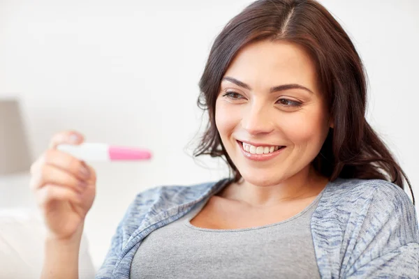 Happy woman looking at home pregnancy test — Stock Photo, Image