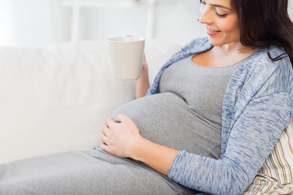 Närbild på gravid kvinna dricker te hemma — Stockfoto