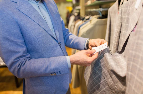 Close up of man choosing clothes in clothing store — Stock Photo, Image