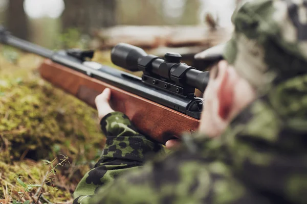 Soldier or hunter shooting with gun in forest — Stock Photo, Image