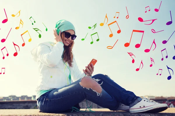 Jovem feliz com smartphone e fones de ouvido — Fotografia de Stock