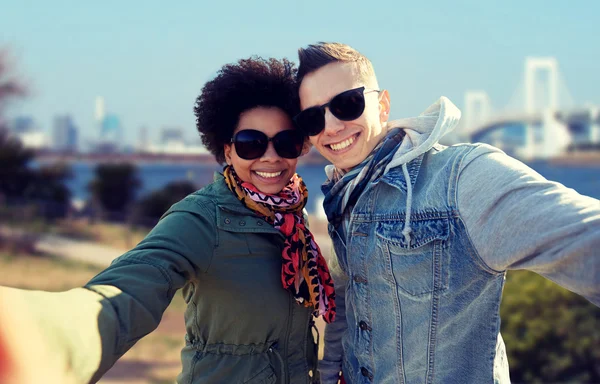 Feliz adolescente pareja tomando selfie en tokyo — Foto de Stock