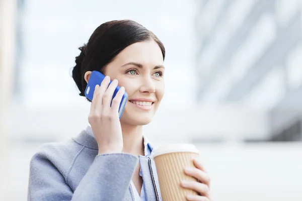 Sonriente mujer con café llamando en smartphone — Foto de Stock