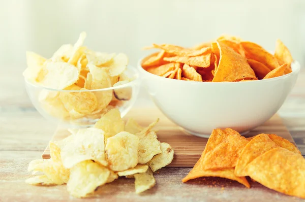 Close up of potato crisps and nachos in glass bowl — 图库照片