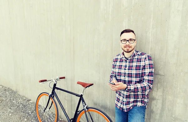 Hipster man in earphones with smartphone and bike — Stock Photo, Image