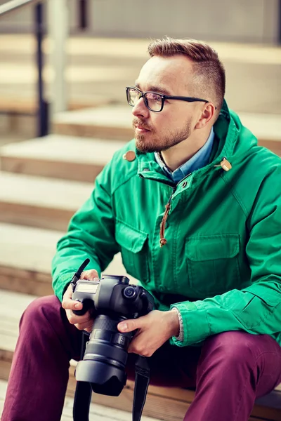 Jonge hipster man met digitale camera in stad — Stockfoto