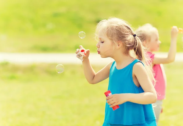 Gruppe von Kindern pustet Seifenblasen im Freien — Stockfoto