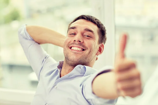 Sorrindo homem mostrando polegares para cima em casa ou no escritório — Fotografia de Stock