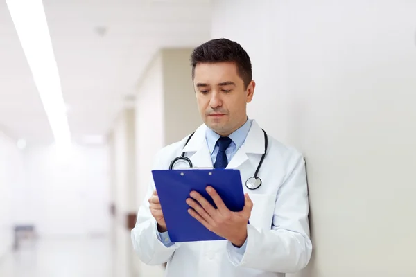 Doctor with clipboard at hospital corridor — Stock Photo, Image
