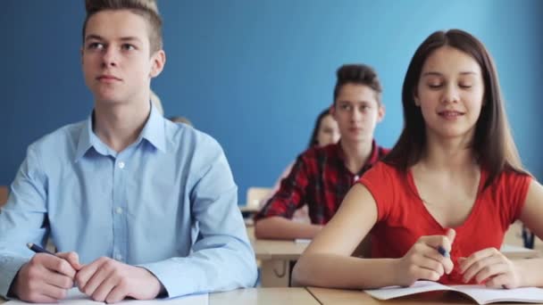 Alunos com cadernos teste de escrita na escola — Vídeo de Stock