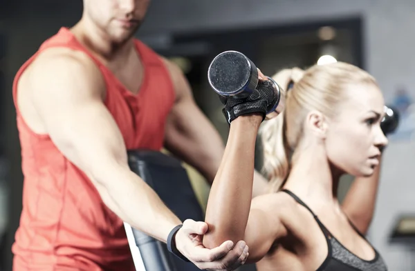 Man and woman with dumbbells in gym — Stock Photo, Image