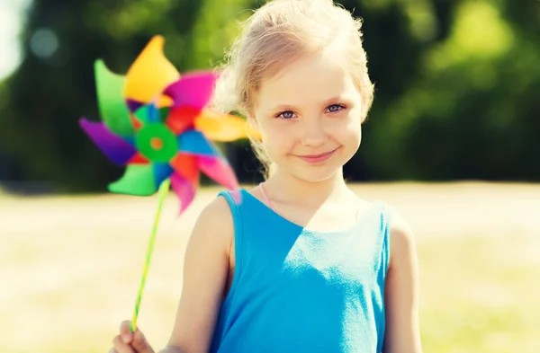 Happy little girl with colorful pinwheel at summer — Stock Photo, Image