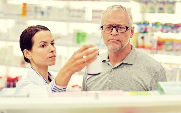 Farmaceuta wyświetlone narkotyków do starszy człowiek w aptece — Zdjęcie stockowe