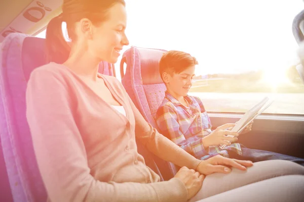 Glückliche Familie mit Tablet-PC sitzt im Reisebus — Stockfoto