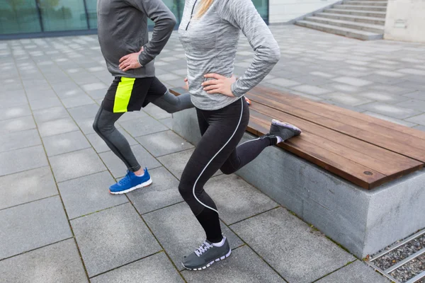 Close up of couple doing lunge exercise on street — Stock Photo, Image