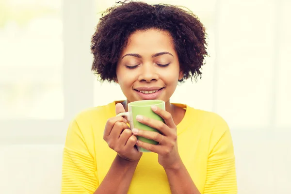 Szczęśliwy african american kobieta pije z filiżanki herbaty — Zdjęcie stockowe