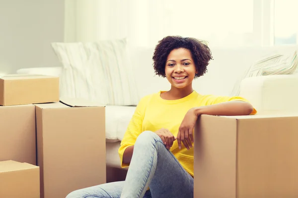 Mulher africana feliz com caixas de papelão em casa — Fotografia de Stock