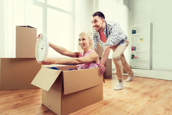 Pareja con cajas de cartón que se divierten en un nuevo hogar — Foto de Stock