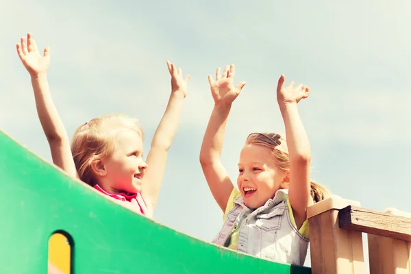 Niñas felices agitando las manos en el parque infantil —  Fotos de Stock