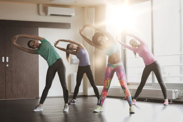 Grupo de mujeres felices haciendo ejercicio en el gimnasio — Foto de Stock