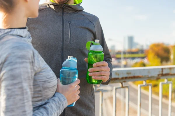 Close up de casal com garrafas de água ao ar livre — Fotografia de Stock