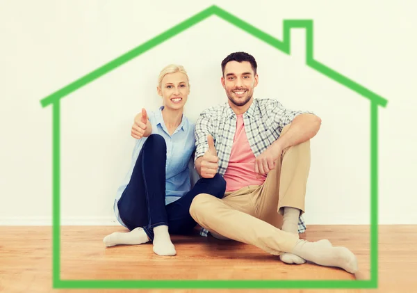 Happy couple showing thumbs up at new home — Stock Photo, Image