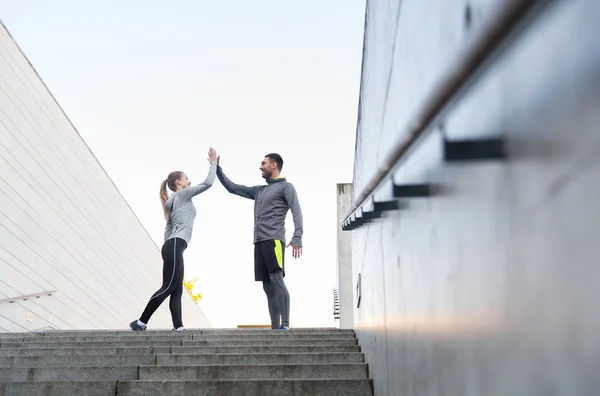 Sonriente pareja haciendo cinco en la calle de la ciudad — Foto de Stock