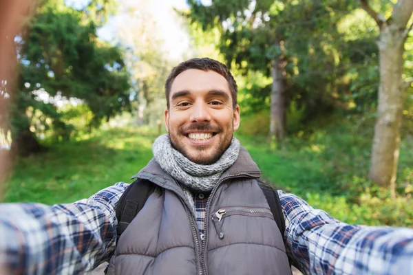 Hombre feliz con mochila tomando selfie y senderismo —  Fotos de Stock