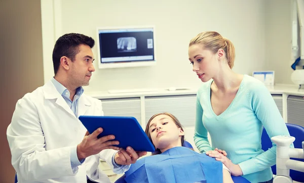 Zahnarzt zeigt Tablet-PC dem Mädchen und ihrer Mutter — Stockfoto
