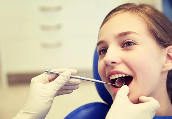 Mains avec miroir dentaire vérifier les dents de fille — Photo