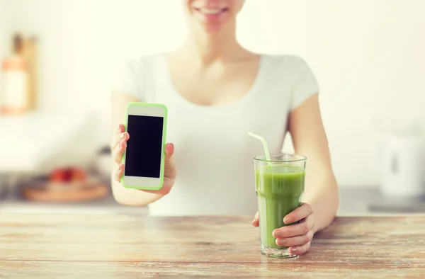 Primer plano de la mujer con teléfono inteligente y jugo verde — Foto de Stock