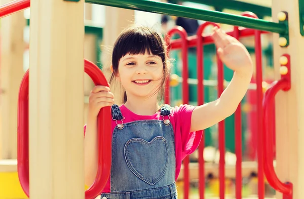 Fröhliches kleines Mädchen klettert auf Kinderspielplatz — Stockfoto