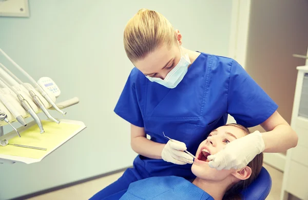 Dentista femenino chequeando dientes de niña paciente — Foto de Stock