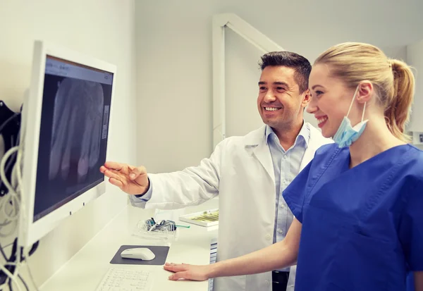 Zahnärzte mit Röntgenbild auf Monitor in Zahnklinik — Stockfoto