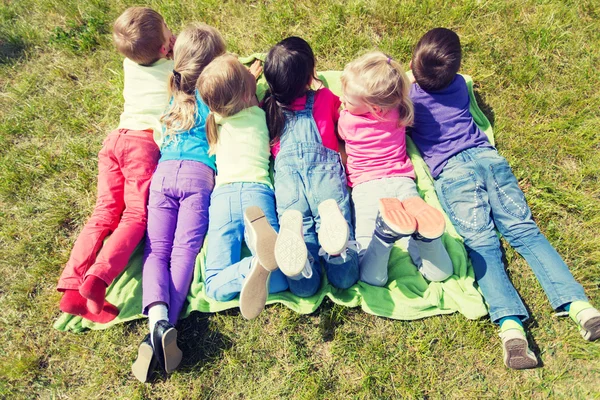 Groep van kinderen liggend op deken of dekking buiten — Stockfoto