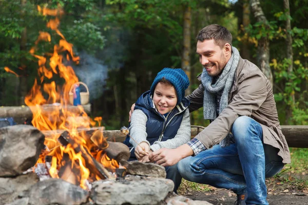 父亲和儿子在篝火烤棉花糖 — 图库照片