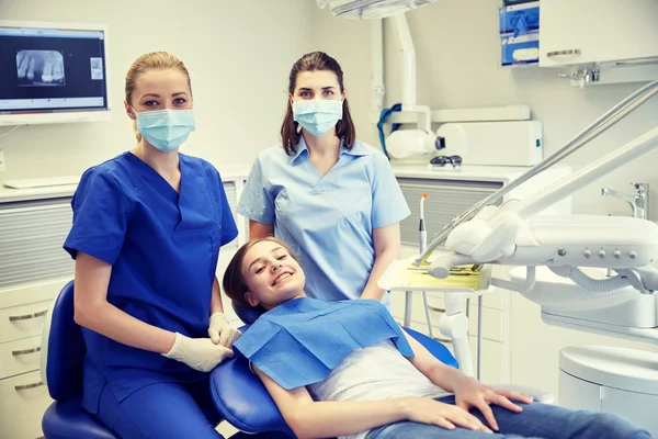 Gelukkig vrouwelijke tandarts met meisje van de patiënt bij kliniek — Stockfoto