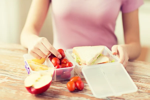 Close up of woman with food in plastic container — Stock Photo, Image