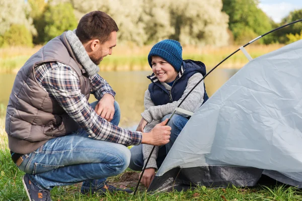 Feliz pai e filho a montar tenda ao ar livre — Fotografia de Stock