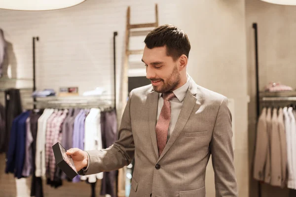 Gelukkig jonge man kiezen ' bow-tie in kledingwinkel — Stockfoto