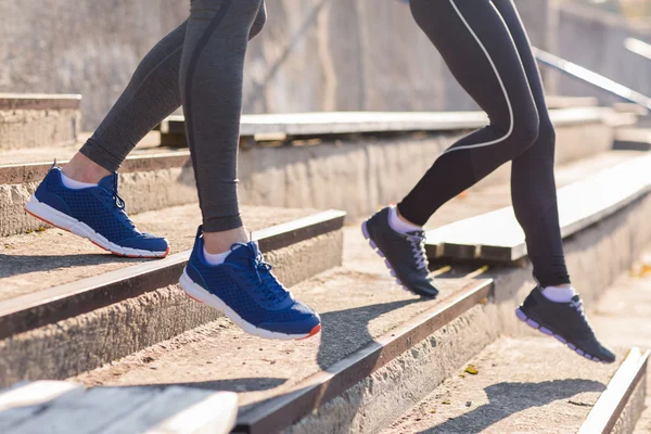 Close up of couple running downstairs on stadium — Stock Photo, Image