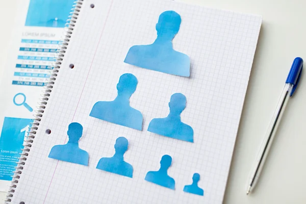 Close up of paper human shapes on notebook — Stock Photo, Image