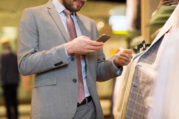Férfi ruházati boltban smartphone közelről Jogdíjmentes Stock Fotók
