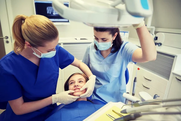 Happy female dentist with patient girl at clinic — Stock Photo, Image