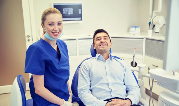 Mutlu kadın dişçi klinikte adam hastayla — Stok fotoğraf
