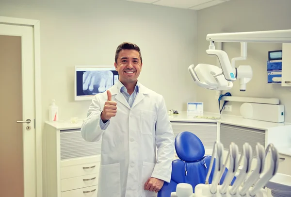 Happy male dentist showing thumbs up at clinic — Stock Photo, Image