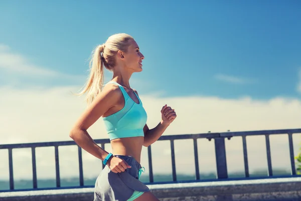 Smiling young woman running outdoors — Stock Photo, Image